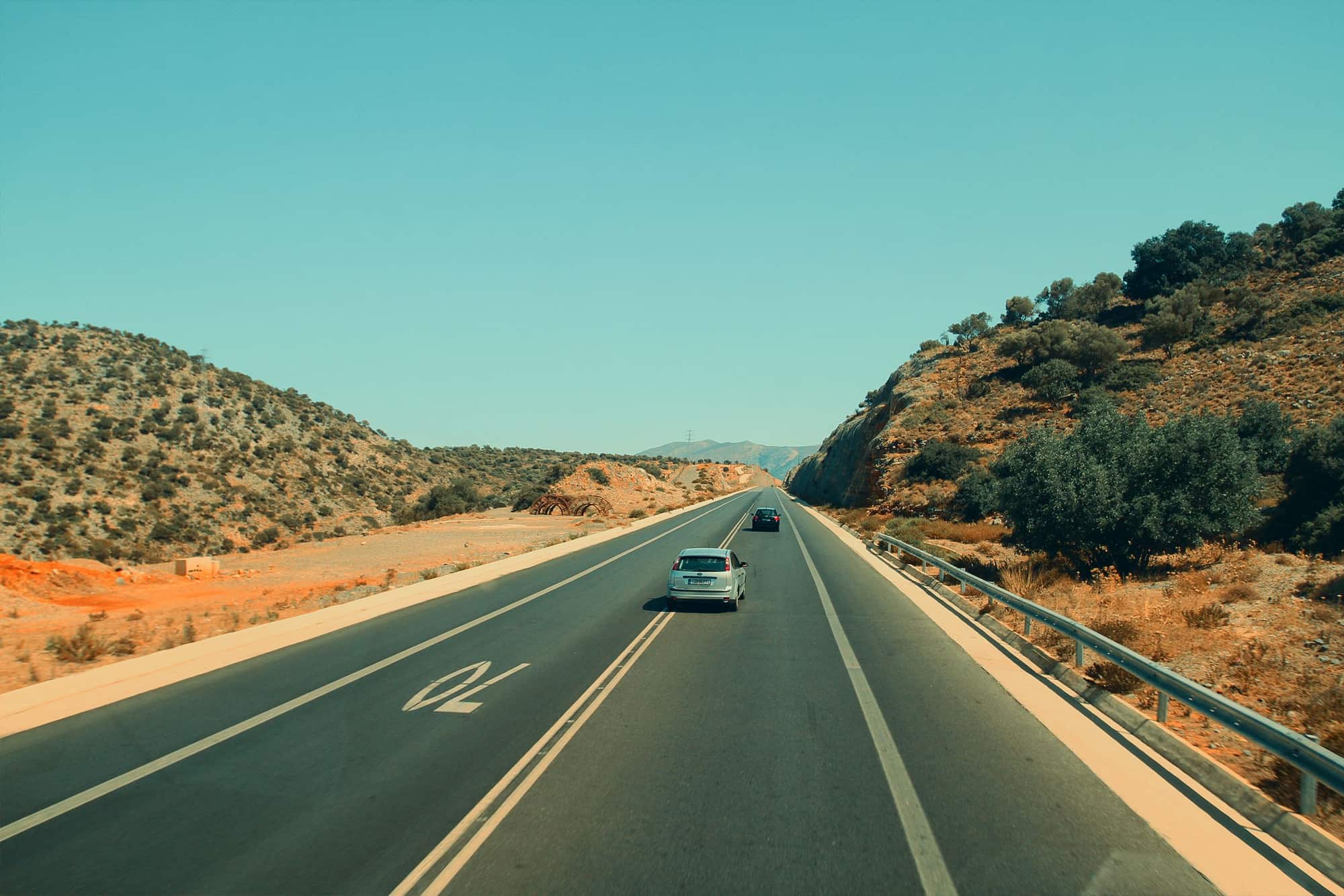 An open highway running through dry hills in the Canary Islands