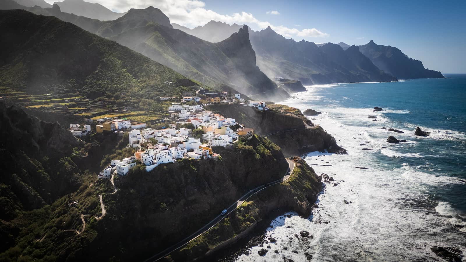 Un pueblo costero bajo laderas aterrazadas en la costa canaria